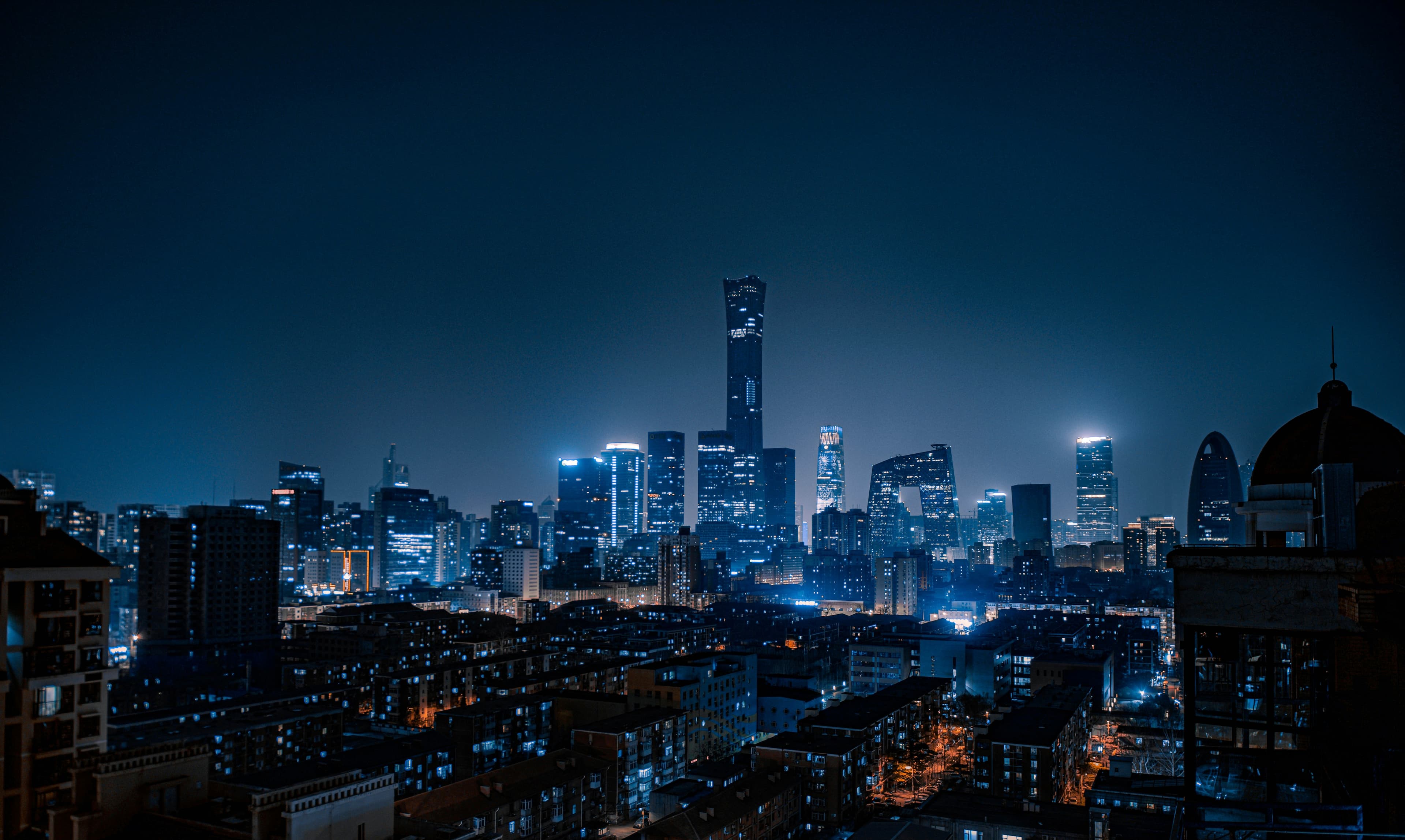 Die Skyline einer beleuchteten Großstadt bei Nacht – gut zu erkennen, wie hell der Himmel darüber aufgehellt wird